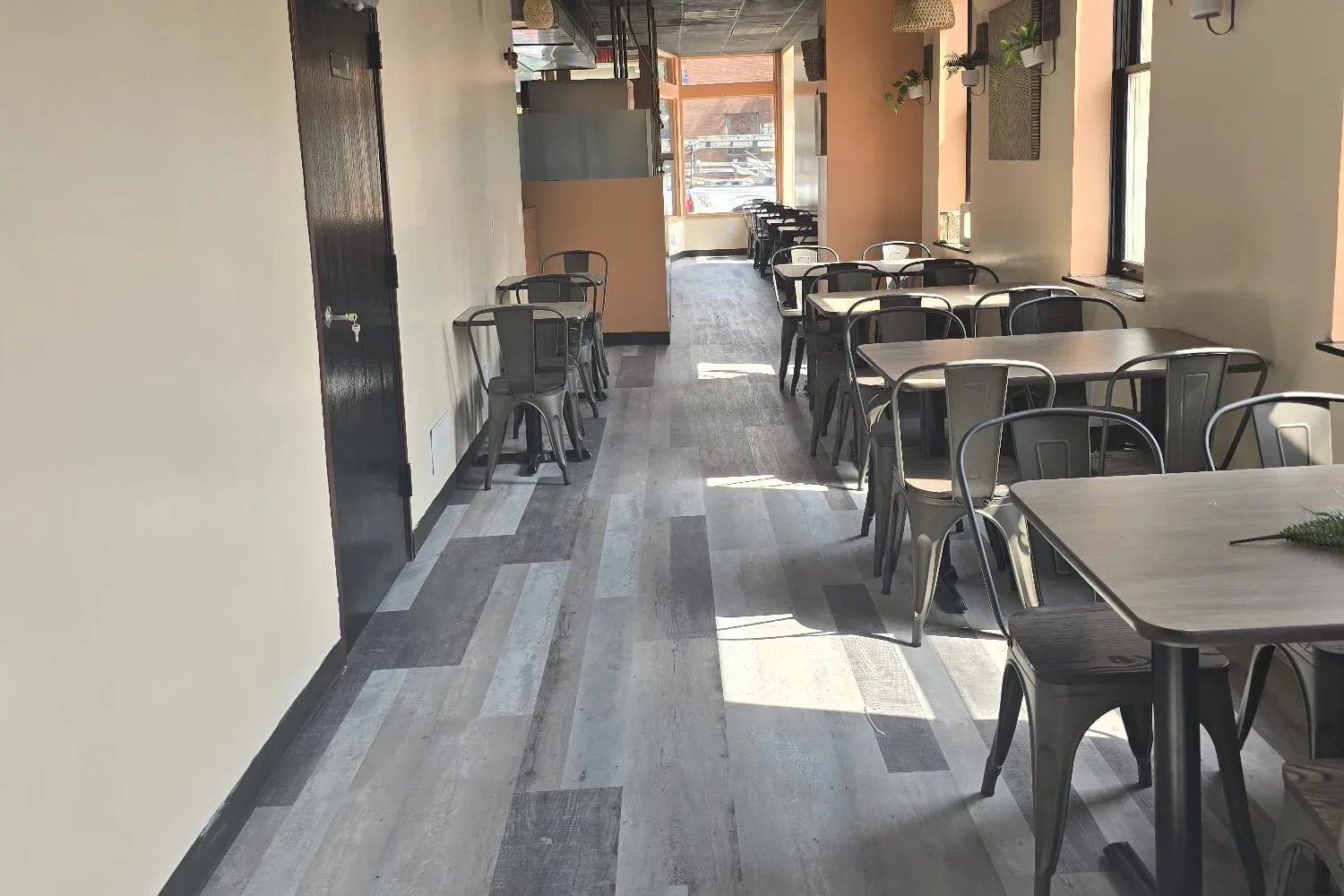 A finished restaurant dining room with tables and chairs in place