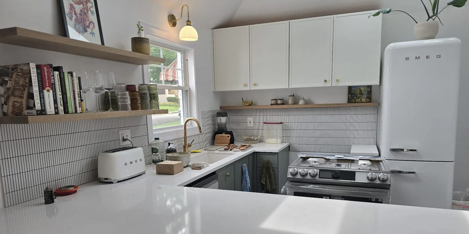 A bright kitchen with white cabinets, open shelving and a subway tile backsplash