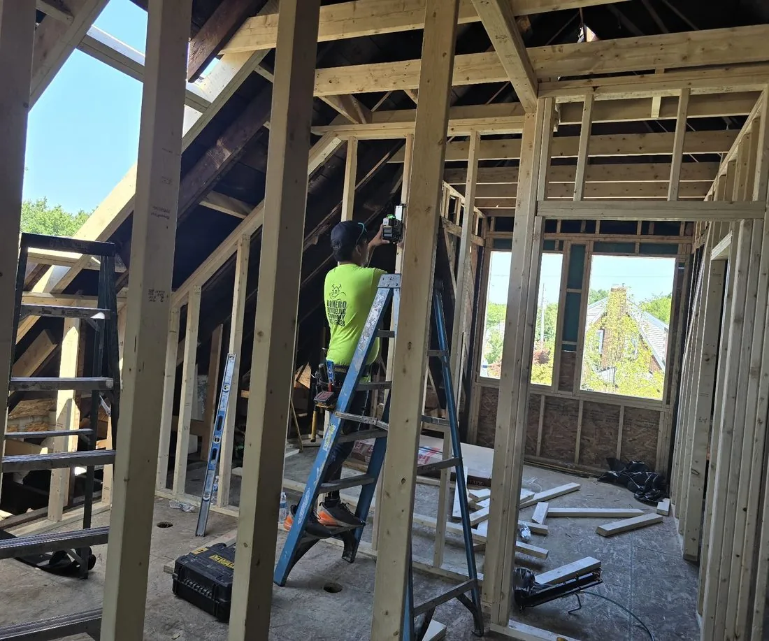 New wall framing going up inside a gutted house