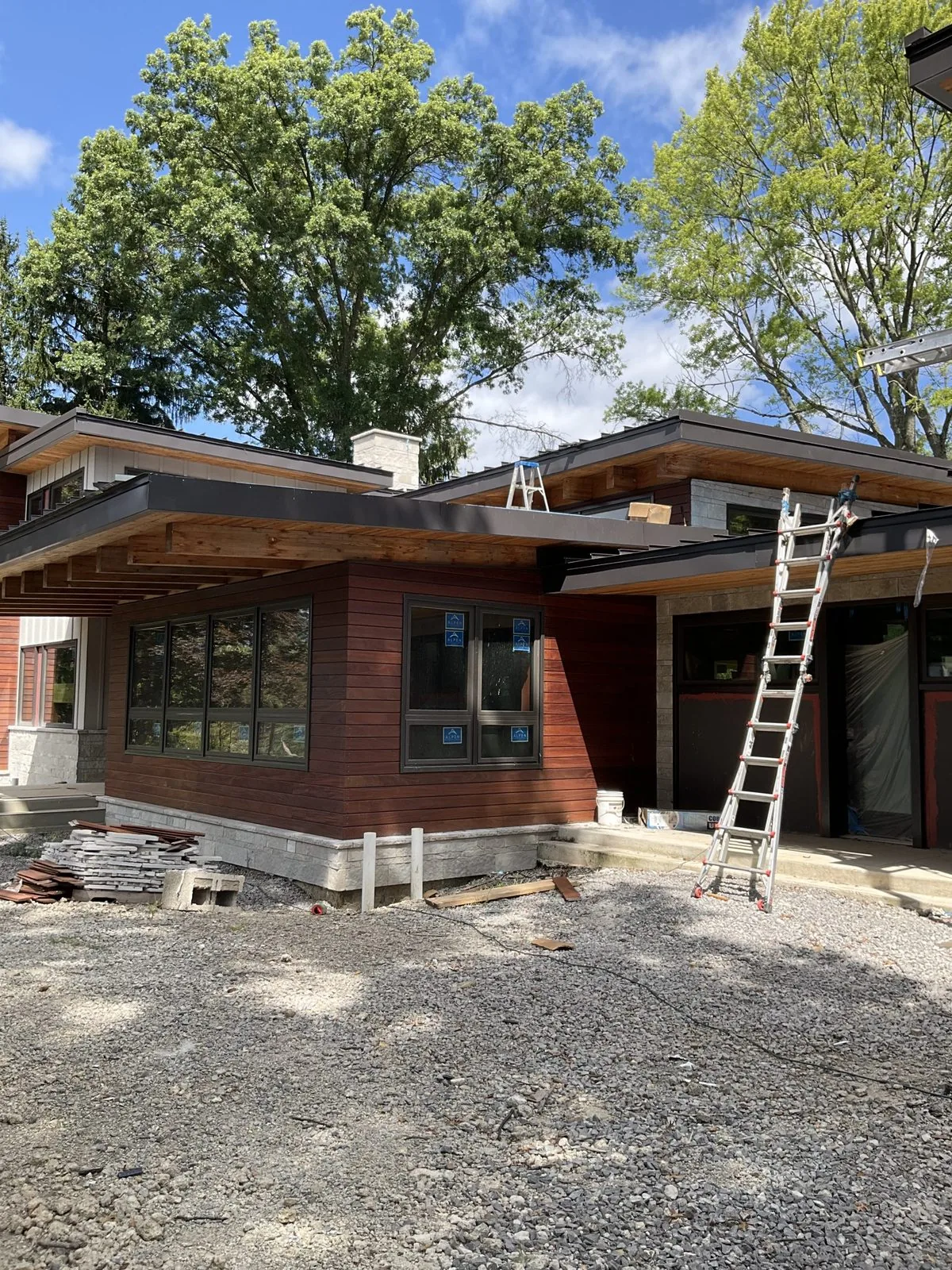 Exterior work on a home with a ladder still standing against the wall