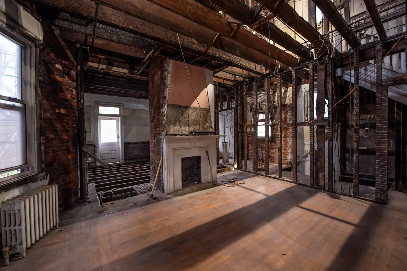 An old interior opened up to the joists with the hardwood floor still down