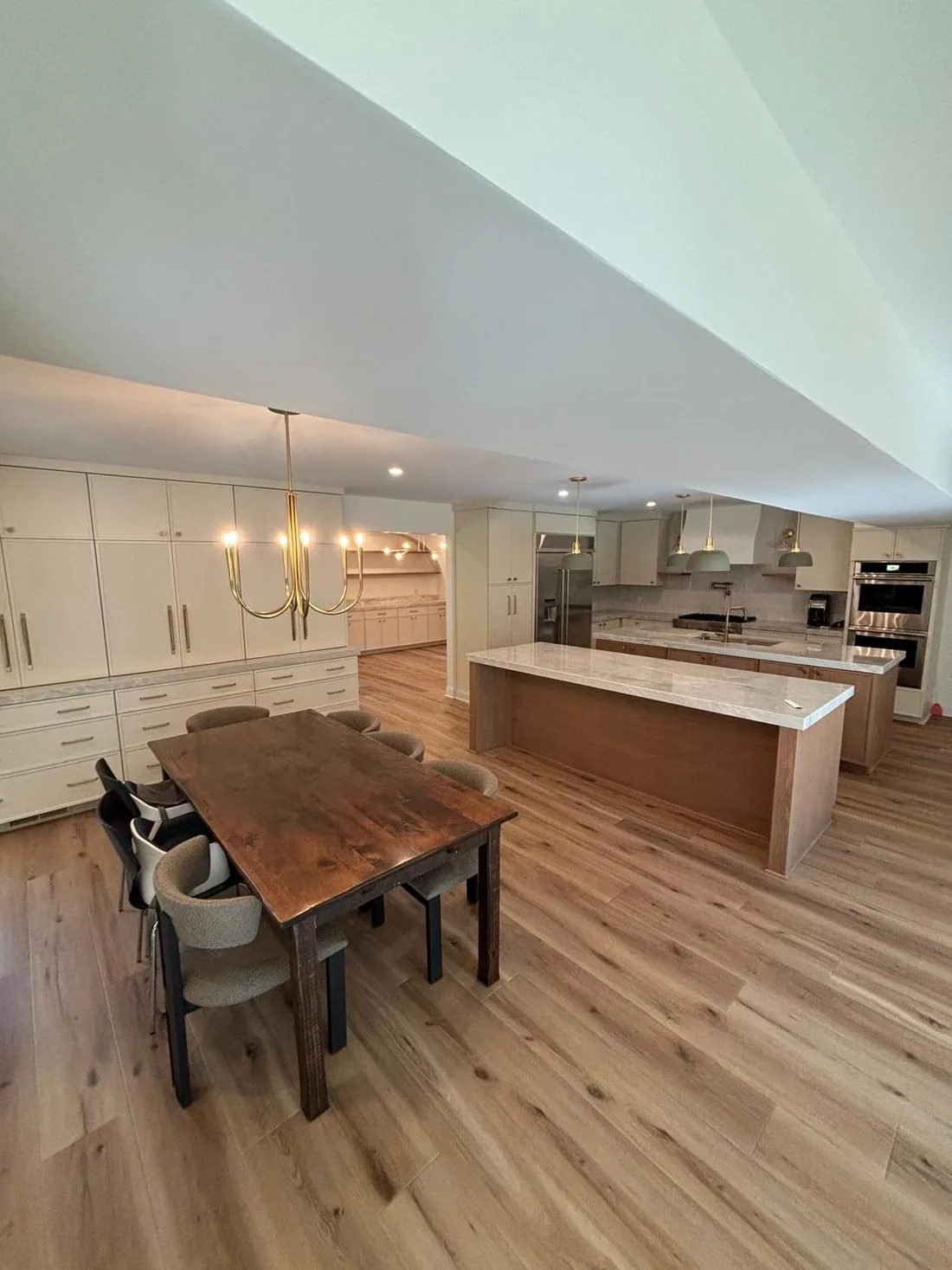 A white kitchen open to a dining area with a live-edge wood table