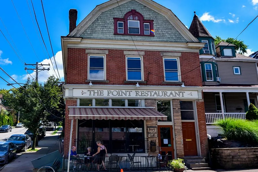 A brick corner building with a storefront at street level